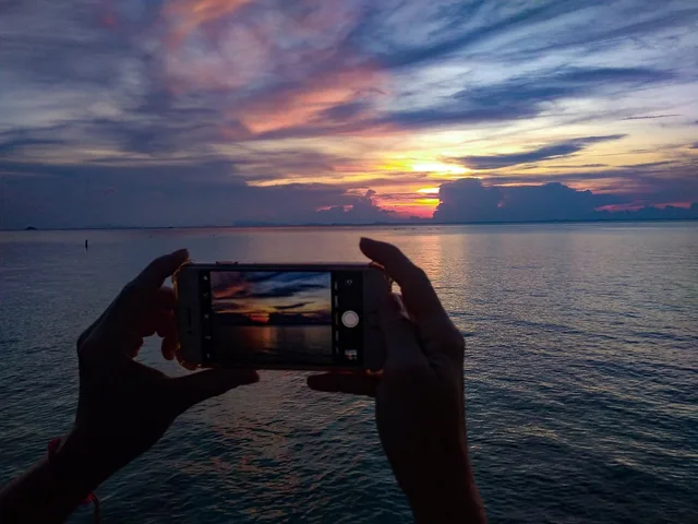 solnedgång i telefonen, håller telefonen, smartphone, mobiltelefon, thailand, ö, solnedgång silhuett, håller telefonen vid solnedgången, kvinna ta bilder på solnedgången, att ta bilder på solnedgången, atmosfärisk, natur, hav, asien, solnedgång, landskap, moln, himmel, ta bilder, kvinnan håller telefonen, kvinna med mobiltelefon i solnedgången, händer som håller i en smartphone på sunset, håller smartphone, blå telefon, blue mobile, blå smartphone. Byta mobiloperatör: data, roaming och bindningstid